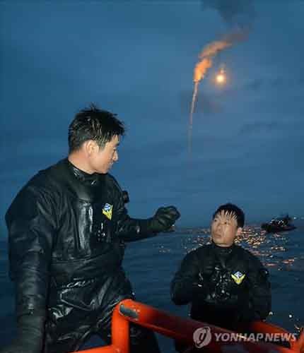 ▲ 지난 18일 밤 구조대원들이 해군의 조명탄 지원 아래 구조작업을 벌이는 모습. ⓒ연합뉴스. 무단전재 및 재배포 금지.