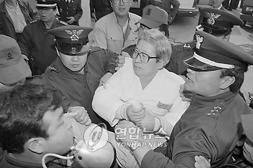 ▲ 오대양 사건과 관련돼 구속된 당시 세모 사장 유병언씨가 교도관의 보호를 받으며 재판을 받기 위해 대전지방 법원에 출두하고 있다.   [사진 출처 = 연합뉴스]