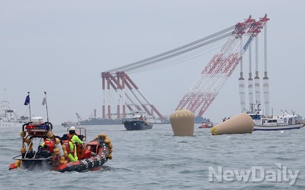 ▲ 세월호 침몰 현장을 둘러싼 조선업체 소속 대형크레인과 공기주머니. ⓒ정상윤 뉴데일리 기자.