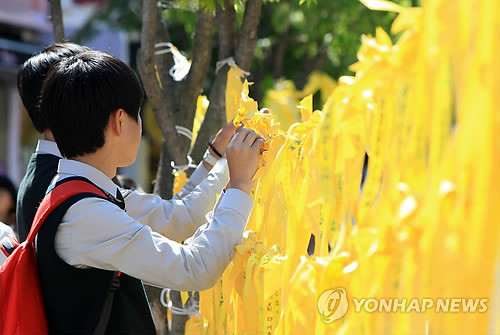 ▲ 3일 세월호 희생자를 추모하기 위해 모인 속초청소년 YMCA 동아리연합회 소속 고교생들이 속초시내에 마련된 분향소에서 희생자를 추모하고 실종자의 무사귀환을 바라는 리본을 달고 있다. ⓒ연합뉴스