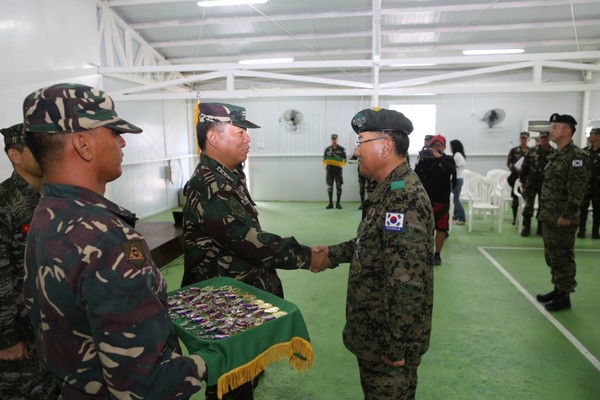 ▲ 바우티스타 필리핀 국방참모총장이 아라우부대장 이철원 대령에게  메달을 친수하고 악수를 나누고 있다.ⓒ합참