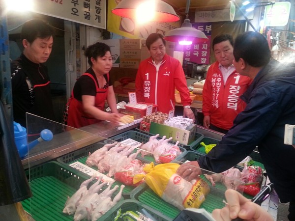 ▲ 22일 신기시장을 찾은 유정복후보는 인지도 확보에 주력했다. 사진은 닭집을 운영하는 상인이 유 후보에게 재래시장의 애로사항을 토로하는 모습. ⓒ뉴데일리