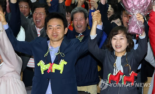 ▲ 새누리당 원희룡 제주도지사 후보와 부인 강윤형씨가 4일 오후 선거사무실에서 당선이 확실시되자 꽃다발을 받고 손을 들어 인사하고 있다. ⓒ연합뉴스