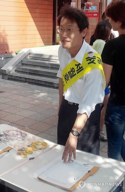 ▲ 조희연 서울시교육감 당선인이 14일 서울 마포구 홍대입구역에서 세월호 참사 관련 서명운동을 하고 있다.ⓒ 사진 연합뉴스