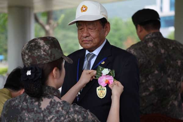 ▲ 6.25참전용사 선배들에게 꽃을 달아주는 국군지휘통신사령부 장병. [사진: 국군지휘통신사령부 제공]