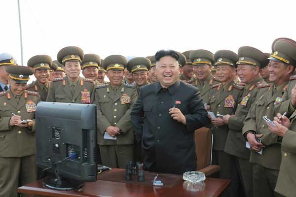 ▲ "봐, 내가 뭐랬어? '독침' 놓는다니까 꼬박꼬박 존칭 붙이잖아?!" 인민군 사이에서 PC를 앞에 두고 활짝 웃는 김정은. [자료사진]