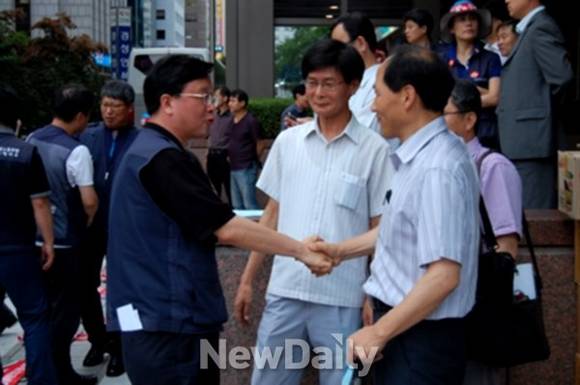 ▲ 김문호 전국금융산업노조위원장(악수하는 좌측 인물)이 윤영대 제3노조 위원장(악수하는 우측 인물)과 시위 현장에서 만나 "힘을 합치자"고 다짐하는 모습. ⓒ 유상석 기자