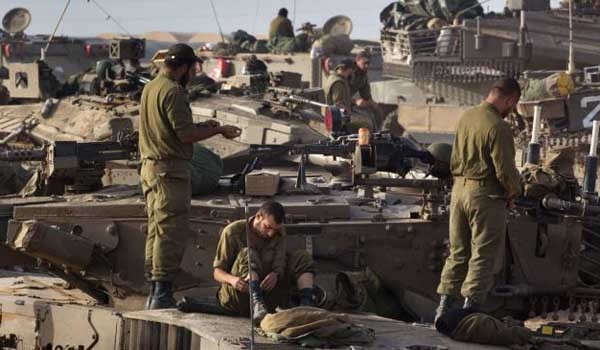가자 지구 인근에서 투입을 기다리고 있는 이스라엘 방위군(IDF) 전차부대원들이 주력 전차 메르카바 위에서 개인정비를 하고 있다. [사진: 이란 프레스TV 보도화면 캡쳐]