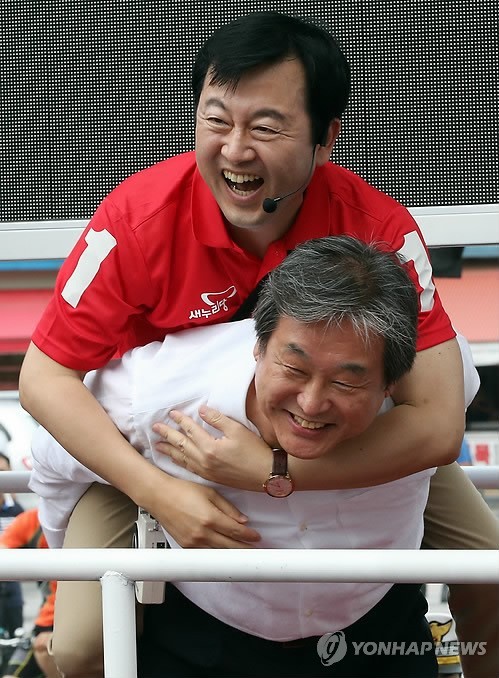 ▲ 17일 오후 경기도 수원시 팔달구 팔달문시장에서 새누리당 김무성 대표(아래)가 7·30 수원병 국회의원 보궐선거에 출마한 김용남 후보를 업은 다음 