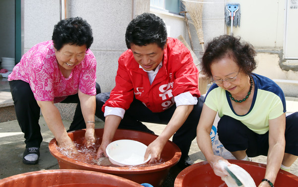 ▲ 경기 평택을 재선거에 출마한 새누리당 유의동 후보가 18일 초복을 맞아 복달임 행사에 참여한 뒤 삼계탕 그릇 등을 설거지하며 봉사하고 있다. ⓒ유의동 후보 선거사무소 제공
