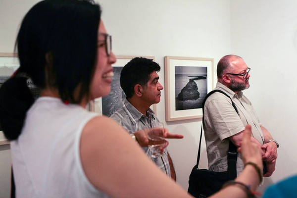 ▲ 런던 전시회 관객들과 대화하며 활짝 웃고 있는 손현주 작가.ⓒ손현주