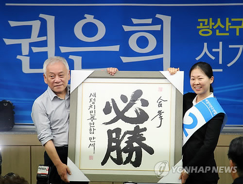 ▲ 새정치민주연합 김한길 공동대표가 15일 오후 광주 광산구에서 7·30 국회의원재보궐선거에 전략공천한 권은희(광주 광산 을) 후보의 선거사무소 개소식에 참석, 권은희 후보에게 '필승'이라고 적힌 글을 주고 있다. ⓒ연합뉴스