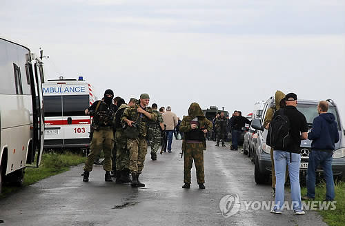 ▲ 크라이나 동부 도네츠크주의 여객기 격추 현장에서 19일(현지시간) 분리주의 반군 세력이 기자들의 취재활동을 통제하고 있다. 사진제공=연합뉴스