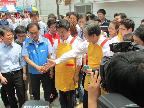 ▲ 21일 경기 평택시 안중시장에서 오전 유세를 진행한 새정치민주연합 안철수 공동대표가 급식 봉사를 준비하던 새누리당 김무성 대표최고위원을 우연히 만난 가운데, 김무성 대표가 안철수 공동대표에게 악수를 청하고 있다. ⓒ정도원 기자