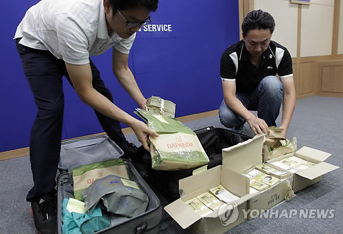▲ 23일 오후 인천시 남구 인천지방검찰청에서 직원들이 유병언 전 세모그룹 회장이 도피하면서 사용했던 여행용 가방 2개를 공개하고 있다. 가방 안에는 4번, 5번이라고 적힌 띠지와 함께 현금 8억3천만원, 미화 16만달러가 들어 있었다.   ⓒ 연합뉴스