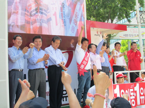 ▲ 25일 경기 평택 비전2동 뉴코아아웃렛 앞 사거리에서 열린 새누리당 유의동 후보 유세에서 후보와 지지자들이 다함께 '기호 1번'을 상징하는 엄지손가락을 힘차게 치켜들고 있다. ⓒ정도원 기자