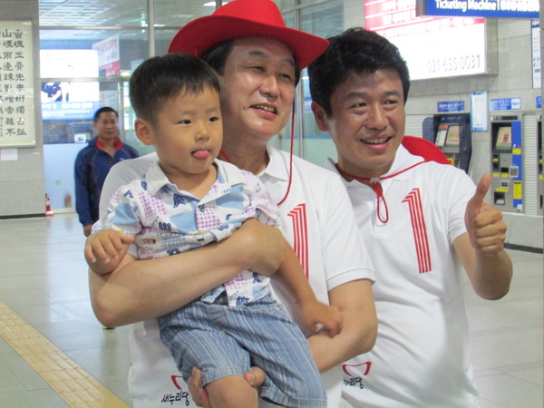 ▲ 경기 평택을 재선거에 출마한 새누리당 유의동 후보와 김무성 대표최고위원이 28일 평택역에서 만난 시민의 요청으로, 아이를 안고 기념 촬영에 응하고 있다. ⓒ정도원 기자