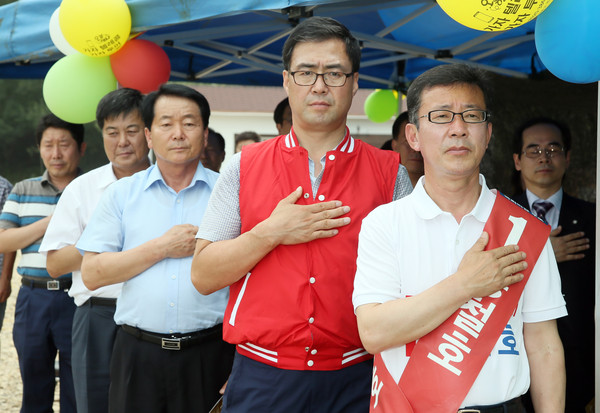 ▲ 경기 김포 보궐선거에 출마한 새누리당 홍철호 후보와 지원 유세를 하고 있는 이만기 교수가 28일 김포 '아이엔지랜드' 개장식에서 국민의례를 하고 있다. ⓒ홍철호 후보 선거사무소 제공