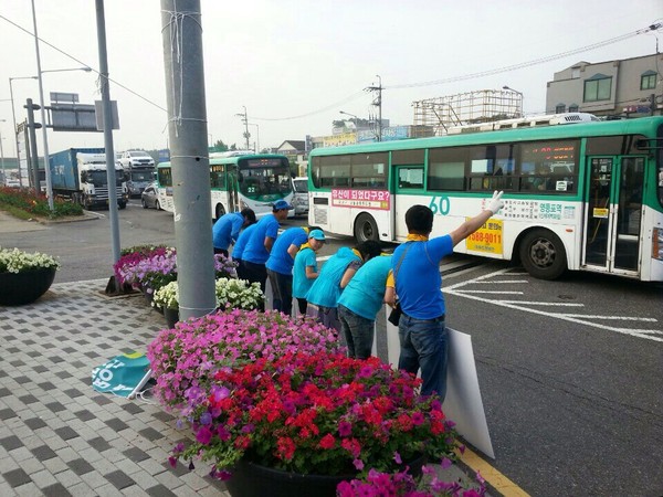 ▲ 새정치민주연합 김두관 후보의 상징색인 파란색으로 옷을 맞춰 입은 사람들이 29일 김포 고촌사거리에서 파란색의 피켓을 들고 자칭 '투표 독려 운동'을 하며 김두관 후보의 '기호 2번'을 상징하는 제스처를 취하고 있다. 오른쪽에서 네 번째로는 어린아이도 보인다. ⓒ홍철호 후보 선거사무소 제공