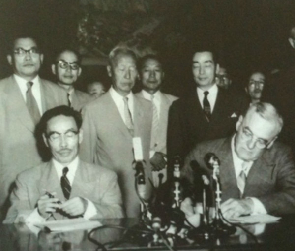 변영태 외무장관(왼쪽)과 미국 덜레스 국무장관이 한미상호방위조약에 서명하는 뒤에 서서 지켜보는 이승만 대통령.(1953.8.8)