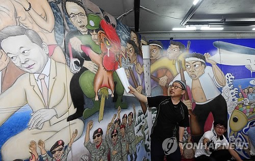 ▲ 박근혜 대통령을 허수아비로 풍자한 걸개그림으로 논란을 빚고 있는 홍성담씨가 8일 오전 광주 금남로 매이홀에서 기자회견을 열어 수정한 작품을 설명하고 있다. 홍씨는 허수아비로 묘사해 논란이 된 박 대통령의 모습 위에 닭을 그려 넣어 "고통받는 민중을 표현했다"고 설명했다. ⓒ 연합뉴스, 무단전재 및 재배포금지