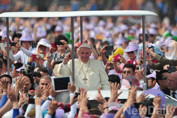 ▲ 16일 서울 광화문 광장에서 시복 미사를 집전하기 위해 프란치스코 교황이 입장하자 신도들이 두 손을 들고 환호하고 있다. ⓒ정재훈 기자