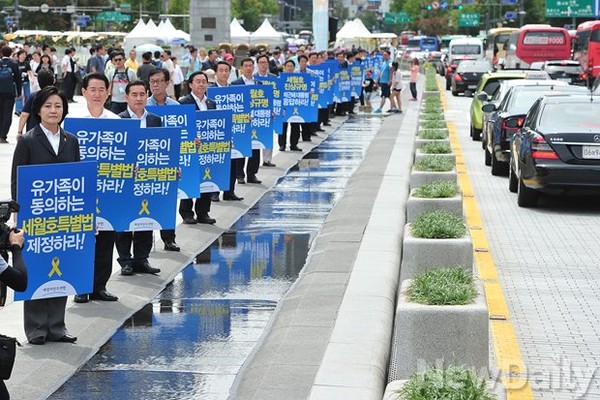 새정치민주연합 의원들이 파란 피켓을 들고 길가에 일렬로 늘어서 있다. ⓒ정재훈 기자