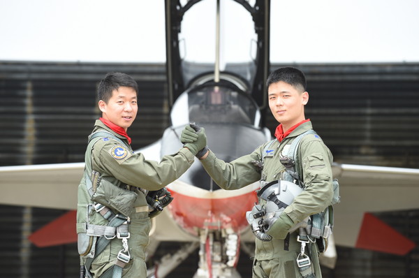 ▲ 힘겹게 조종사의 꿈을 이룬 정윤석 중위(왼쪽)와 이진범 중위(오른쪽)가 서로의 건투를    기원하며 T-50 앞에서 손을 맞잡고 있다. ⓒ공군