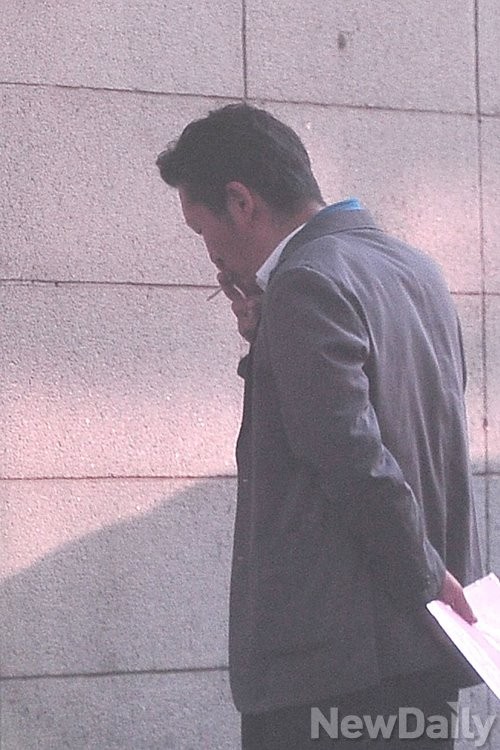 ▲ 차량 밖으로 나온 정 의원의 손엔 담배가 들려 있다. ⓒ뉴데일리