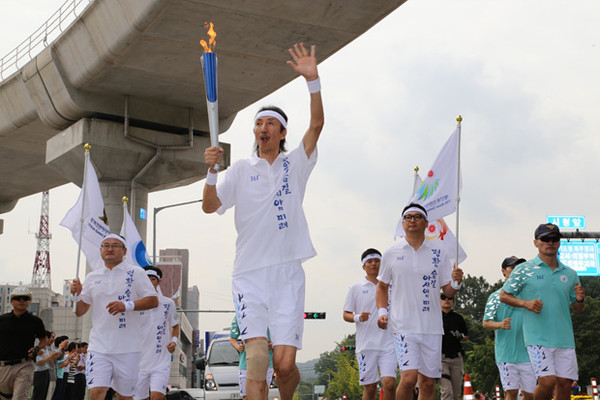 ▲ 전 농구선수 한기범씨가 의정부 성화 주자로 달리고 있다.ⓒ인천AG조직위