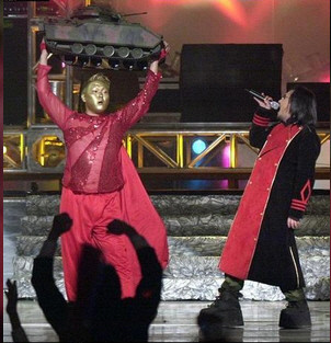 ▲ 싸이가 미군 장갑차 모형을 들고 있다. 옆에서 신해철이 노래를 하고 있다.  ⓒ뉴데일리 DB