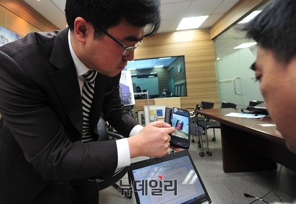 ▲ 휴대전화에 저장된 사진을 보여주는 이 호 목사. ⓒ뉴데일리 정재훈 기자