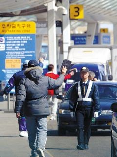 ▲ 인천국제공항 출국장 앞 도로에서 사설주차 대행 서비스업체 직원들이 청원경찰들이 지켜보는 가운데 여행객들을 상대로 버젓이 호객행위를 벌이고 있다. ⓒ조선일보 DB