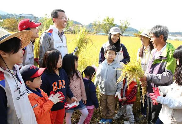 ▲ 아시아나항공 김수천 사장(뒷열 왼쪽 두번째)이 봉사활동에 참가한 임직원 및 외삼포2리 산초울마을 주민들과 함께 벼를 베며 담소를 나누고 있다. ⓒ 아시아나항공 제공.