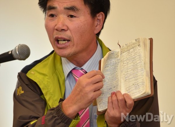 ▲ '정부 지원설'과 관련, 지난달 16일 대북전단 살포에 대한 토론회에서 북한직접돕기운동 이민복 단장이 후원내역이 빼곡히 적힌 수첩을 꺼내보이고 있는 모습. 2014.10.16 ⓒ뉴데일리 정상윤 기자