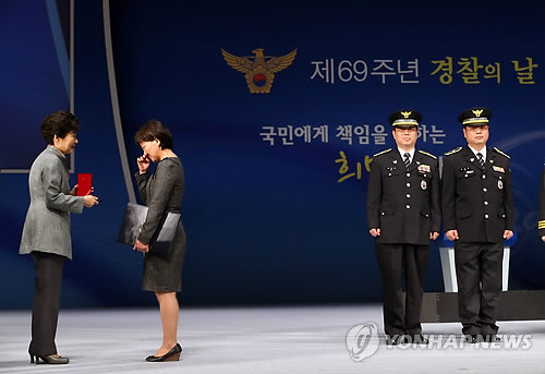 ▲ 박근혜 대통령이 21일 오후 서울 종로구 세종문화회관에서 열린 제69주년 경찰의 날 기념식에서 유공자 표창을 하고 있다. 범죄 용의 차량을 추격하다 부상해 14년간 투병하다 사망한 광주광역시 광산서 신종환 경사를 대리해 수상한 부인 왕춘자 씨가 훈장을 받으며 울먹이고 있다. ⓒ연합뉴스