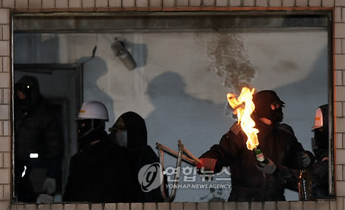 ▲ 서울 용산 4구역 철거민대책위원회 회원들이 밤샘 농성중인 한강대로변 재개발지역의 한 건물에 경찰의 강제진압이 시작되자 화염병 새총을 쏘며 저항하고 있다 2009.1.20. [저작권자(c)연합뉴스. 무단전재-재배포금지]