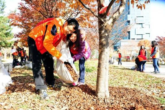 ▲ SK건설은 지난 15일 서울 성동구 서울숲에서 고형비료와 우드칩을 깔아주는 가족봉사활동을 실시했다. SK건설 임직원 및 가족 봉사단이 우드칩을 깔아주고 있다.ⓒSK건설