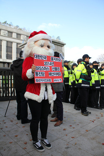 ▲ 루돌프, 북한 김정은, 산타클로스 복장을 하고 릴레이 1인 시위를 펼치고 있는 청년들 2014.11.24 ⓒ스토리케이 제공