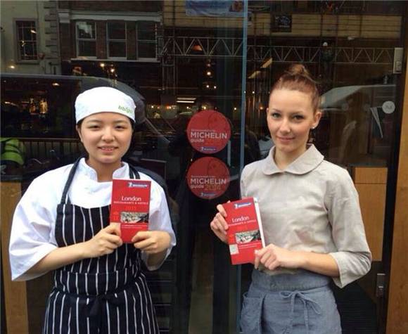 ▲ ⓒ비비고 영국 런던 소호점 앞에서 직원들이 미슐랭가이드 2년 연속 등재를 기념하며 미슐랭가이드를 들고 포즈를 취하고 있다. 사진=CJ푸드빌 제공