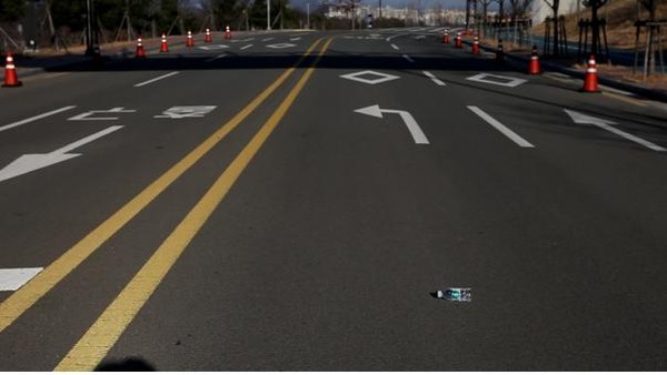 ▲ 대구미술관 관람객이 물병이 데굴데굴 굴러 올라가는 것을 믿지 못하는 듯 실험해보고 있다.ⓒ대구시 제공