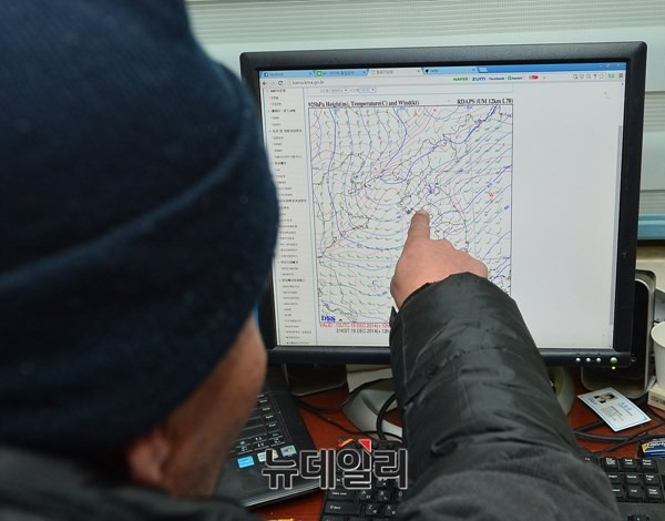 ▲ 전단을 날리기 전 시민활동가 강재천씨가 항공기상청에서 풍향을 확인하고 있는 모습. 2014.12.19.ⓒ 뉴데일리 정상윤 기자