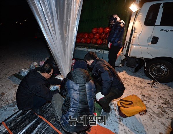 ▲ 시민활동가들이 수소를 넣은 풍선에 전단, 라디오, DVD 등이 담긴 묶음을 달고 있다. 2014.12.19.ⓒ 뉴데일리 정상윤 기자