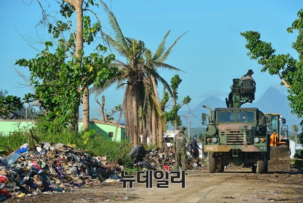 필리핀 재건작전인 '엔젤작전' 펼치는 아라우부대. 한국에서 가져온 중장비를 이용해 태풍잔해로 막힌 길을 치우고 있다. ⓒ뉴데일리
