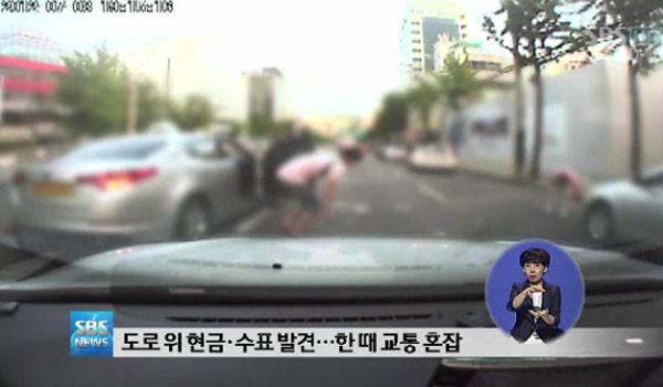 ▲ 2012년 7월 8일 서울 역삼동 한 도로에서 있었던 '돈벼락' 사건. '돈벼락' 사건이 일어날 경우 돈 회수율은 0%에 가깝다. ⓒ당시 SBS 보도화면 캡쳐