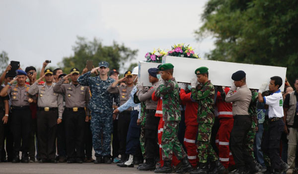 ▲ 인양한 시신을 운구하는 인도네시아 군인들. 수색작업을 돕기 위해 온 다른 나라 군인들이 경례를 하고 있다. 인도네시아 당국은 에어아시아 여객기 승객들의 수색인양작업에 최우선 순위를 두고 있다고 밝혔다. ⓒCNN 에어아시아 보도화면 캡쳐