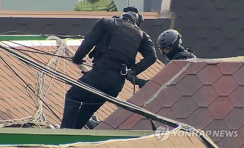▲ 13일 오후, 경찰특공대원들이 경기 안산 상록구 소재 다세대주택 4층에서 인질극을 벌이고 있는 범인 검거를 위해, 해당 주택 옥상에서 건물 아래로 내려가고 있다.ⓒ 사진 연합뉴스