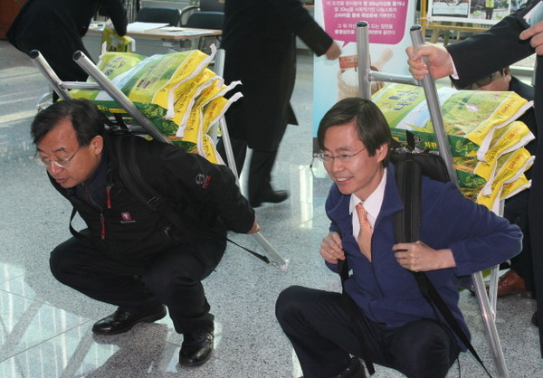 ▲ 새누리당 이정현 최고위원(왼쪽), 새정치민주연합 조경태 의원이 20일 서울 여의도 국회 의원회관에서 쪽방촌 주민들을 위한 쌀 기부 행사 '라이스버킷 챌린지'에 도전하고 있다. ⓒ조경태 의원실