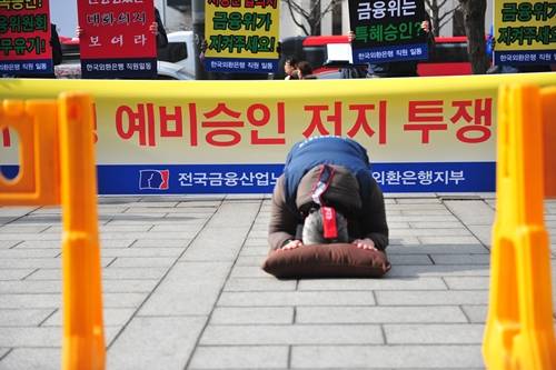 ▲ 외환은행 노조가 하나금융의 예비인가 신청에 반발해 금융위 앞에서 108배 하며 시위하는 모습. ⓒ 전국금융산업노조 외환은행지부 제공