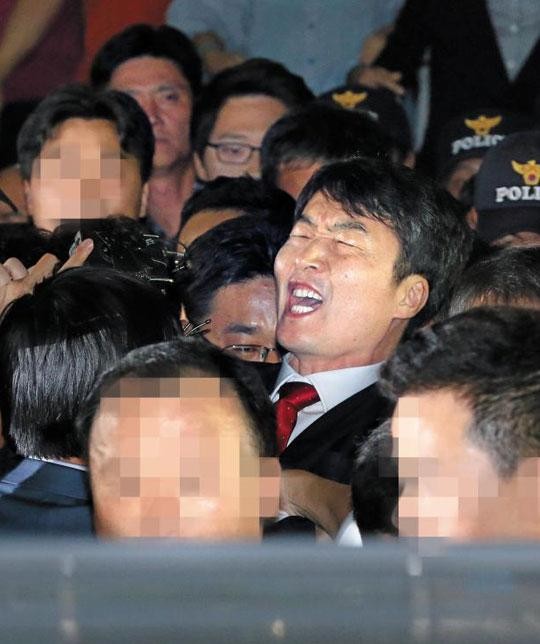 ▲ 이석기 전 통진당 의원이 경기 수원 남부경찰서에서 수사 관계자들에 이끌려 호송차로 이동하면서 고함을 지르고 있는 장면. ⓒ조선일보 사진 DB